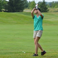 An alumna golfing at The Meadows Golf Course.
